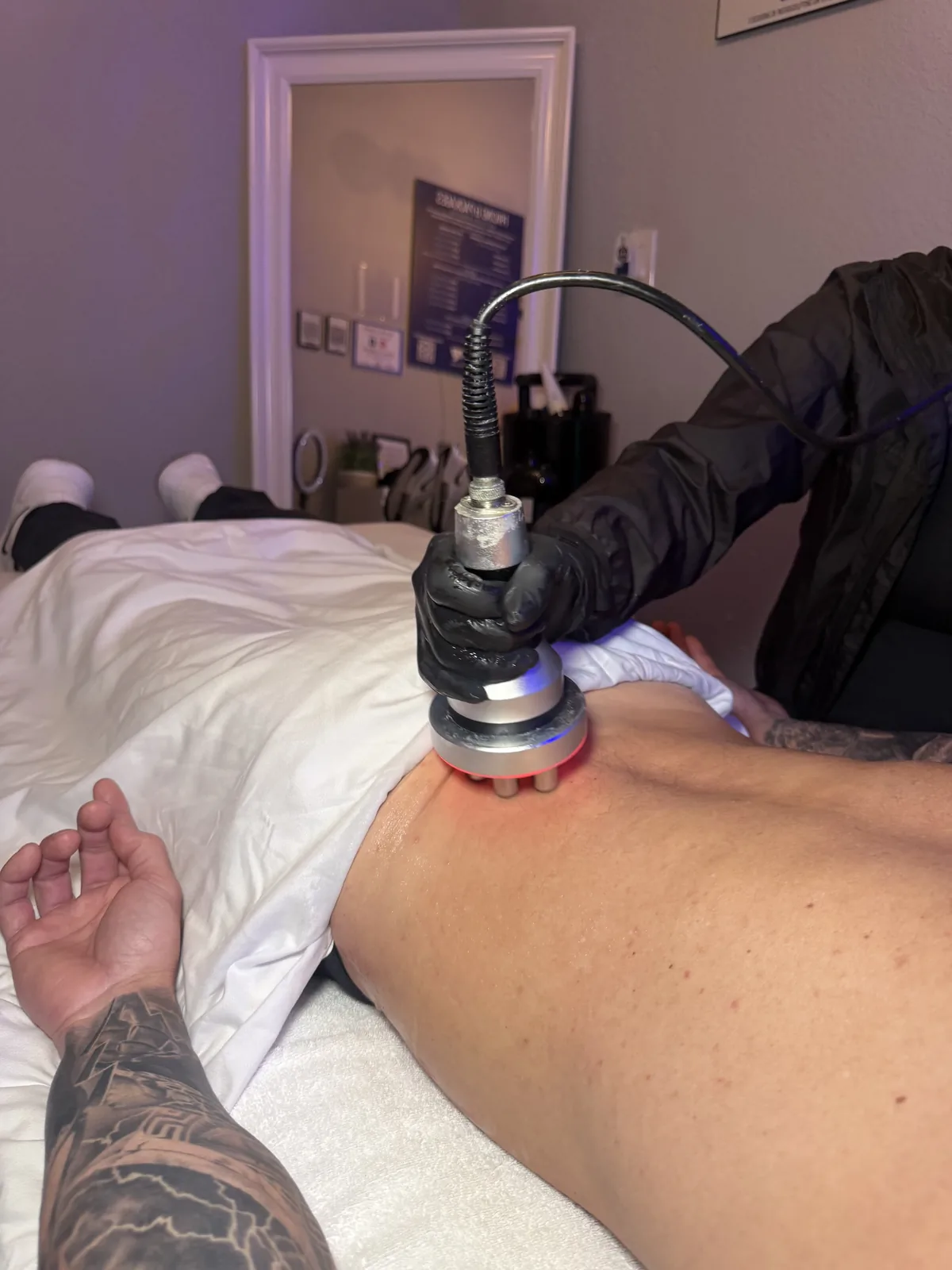 Close-up of the InstaSculpting applicator handpiece during a session